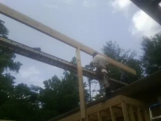 Carpenter setting a ridge beam over a new addition frame — Ice Dam Removal by Roofing Brothers in Volga