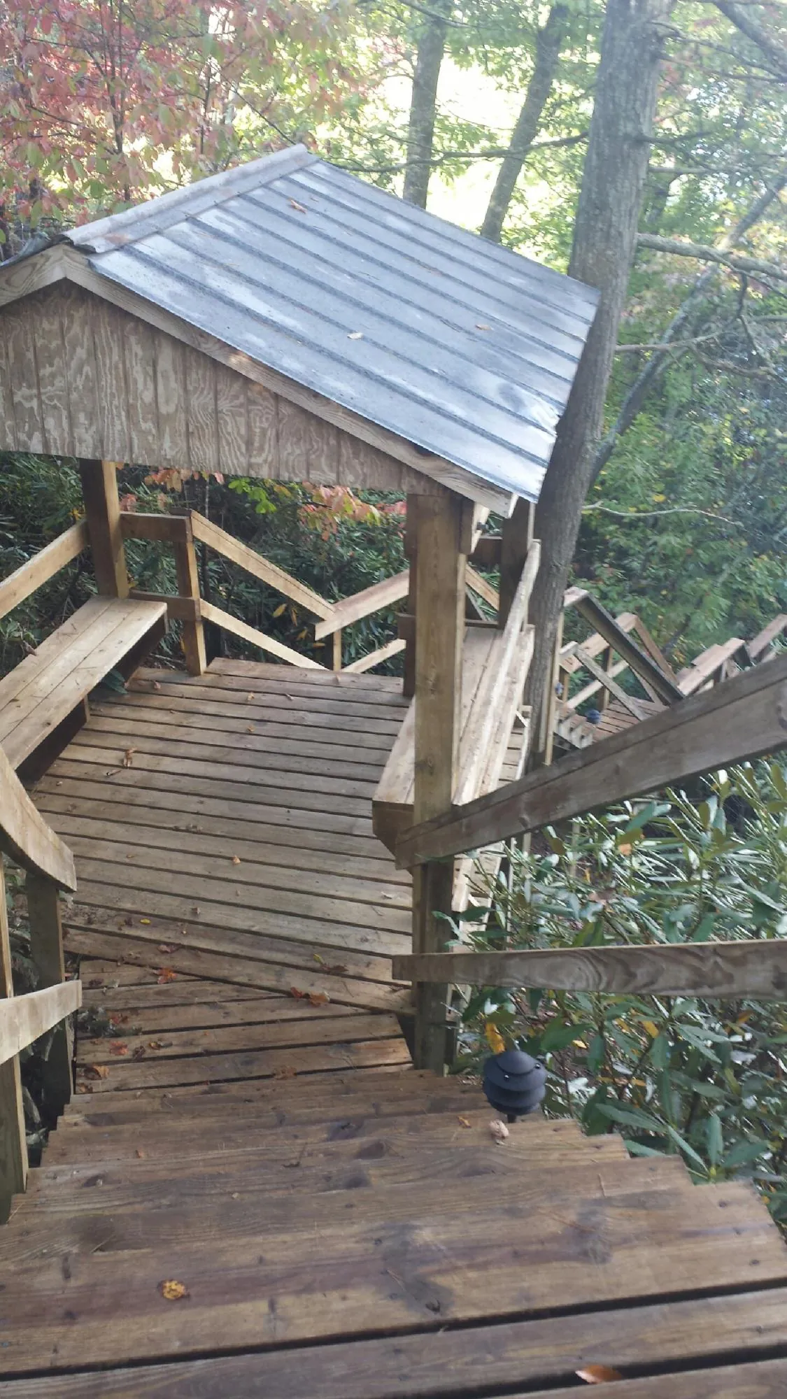 Metal roofed shelter over wooden steps on a wooded walkway — Skylight Repair & Installation work by our crew in Volga